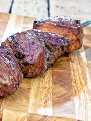 Cooked Meat Picanha skewer ready to eat leaning on chopping board