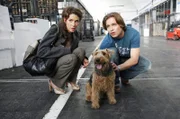 Während einer Locationsuche läuft Bruno (Tim Sander, r.) ein herumstreunender Hund zu. Nora (Julia Malik, l.) ist zunächst von der Ablenkung nicht begeistert, doch als Bruno überlegt, den Hund seinem Vater zu schenken, ist sie von Brunos Fürsorge gerührt.