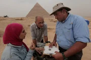 Kairo, Ägypten - Sara, Mohamed und Ashraf vor den Pyramiden, beim Betrachten des Siegelstempels, der in der Grabstätte gefunden wurde. (Windfall Films)