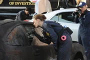 Brennan (Emily Deschanel) macht sich vorsichtig ein Bild von der vekohlten Leiche in dem ausgebrannten Auto.