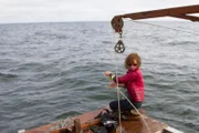 Emily Riedel kneeling on a dredge.