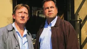 Stefan Kehler (Wolfgang Bathke, re.) und der Drogeriebesitzer Paul Borowski (Raimund Gensel) sind dabei, als in der abgebrandten Drogerie die Leiche einer Frau gefunden wird.