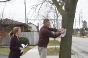 Charles und Hannah stecken das Poster der vermissten Person an den Baum