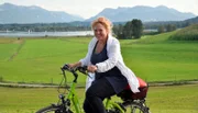 Auf dem Fahrrad erkundet die gebürtige Chiemgauerin Gertraud Dinzinger (im Bild) den geliebten See ihrer Kindheit neu, nimmt sich Zeit für spontane Begegnungen und ungeplante Abstecher und entdeckt dabei die verborgenen, zauberhaften und kuriosen Seiten des "bayerischen Meers" und seiner Umgebung.