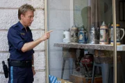Polizeihauptmeister Mohr (Max Müller) hat von Kommissar Stadler genaue Anweisungen bekommen, welchen Bierkrug er ihm besorgen möge. Was niemand ahnt: Die Reihenfolge der Bierkrüge im Schaufenster wurde verändert.