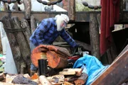 PORT PROTECTION, Alaska - After a successful community effort to repair the boardwalk, Gary Muehlberger splits firewood behind his house in Port Protection, AK. (Photo Credit: National Geographic Channels/Corey Cooper)