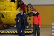 Fasziniert hört Rudi (Michael Pascher, r.) den Ausführungen von Gert (Martin Leutgeb, l.) über seinen aufregenden Einsatz zu. Doch dabei wurde der Rettungshubschrauber beschädigt, so dass für Michi (Robert Lohr, M.) der Arbeitstag noch nicht zu Ende ist.