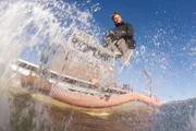 Zeke Tenhoff jumping into the Bering Sea.