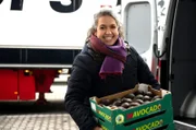 Günes Seyfarth mit einer Kiste voller Avocados.