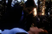 Mulder (David Duchovny, l.) und Richie (Judd Trichter, r.) kümmern sich um Scully (Gillian Anderson, M.), die auf der Suche nach einem Ufo ohnmächtig geworden ist.