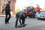Mattes (Matthias Schloo, r.) will Melanie (Sanna Englund, l.) davon überzeugen, dass sich das vermisste Handy am Unfallort unter einem Kanaldeckel befinden könnte.