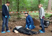 Finn Kiesewetter (Sven Martinek, l.), Pathologe Dr. Strahl (Christoph Tomanek, 2.v.r.) und Sandra Schwartenbeck (Marie-Luise Schramm, r.) mit der Leiche eines Mannes (Thomas Born) aus dem Hamburger Rotlichtmilieu, die auf einem Waldparkplatz gefunden wurde.