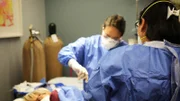 Dr. Lee (r.) and assistant operate.