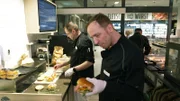 Daniel (re.) und John bereiten Burger zu