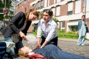 Auf dem Weg zur Arbeit leistet Krankenschwester Betty (Bettina Lamprecht, li.) erste Hilfe, als die hochschwangere Karla (Marie Mayer) auf der Strasse zusammenbricht und gibt dabei einem Passanten (Tugsal Mogul) Anweisungen, wie er die Herzmassage begleitend durchführen muss.