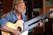 Roland Neuwirth spielt ein Lied in seinem Musikzimmer