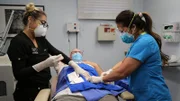 Dr. Lee and assistant operate on Ed.