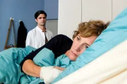 Dr. Behring (Maximilian Grill, l.) überwindet sich und sucht seine Ex-Frau Barbara (Lilia Lehner, r.) in ihrem Krankenzimmer auf.