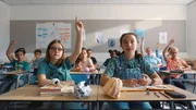Floor (Bobbi Mulder) und Margreet (Romy Voll) sitzen im Klassenzimmer, Floor meldet sich, als der Lehrer fragt, wer dem Schachclub beitreten will.