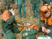 Jakob Heilmanns (Karsten Kühn, links) Ausbilder Hartmut Groß (Uwe Karpa, Mitte) wird mit einer Motorsäge am Oberarm getroffen und schwer verletzt.