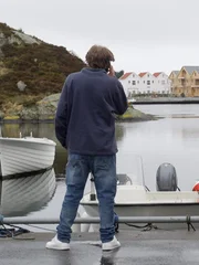 Jake telefoniert und schaut aufs Wasser hinaus.