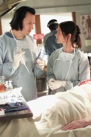 CROSSING JORDAN -- NBC Series -- "The Truth is Out There" -- Pictured: (l-r) Steve Valentine as Dr. Nigel Townsend, Jill Hennessy as Dr. Jordan Cavanaugh -- JORDAN AND NIGEL FIND THAT STORE GREETER DIED OF ROUTINE HEART ATTACK ONLY TO HAVE MORGUE VISITOR ATTEMPT TO STEAL BODY IN BIZARRE TWIST