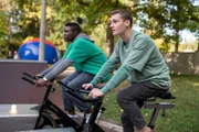 Badu (Arnold Markuissie, li.) und Viktor (Fridolin Sommerfeld, re.) müssen sich auf den Spinning-Rädern ganz schön ins Zeug legen.