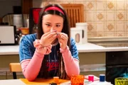 Maja (Godiva Adela) bastelt in der Küche Freundschaftsarmbänder.
