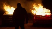Silhouette einer Person vor zwei brennenden Autos   +++