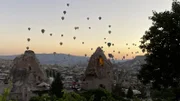 Mehr als 400 Ballons steigen zum Sonnenaufgang über der Stadtkulisse von Göreme auf, ein beliebtes Motiv auf Social Media.