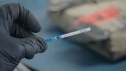 An officer holds a test strip, showing positive for Fentanyl. (National Geographic)