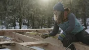 Misty works on a building frame.