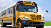 Yellow school bus on the blacktop on a beautiful sunny day.