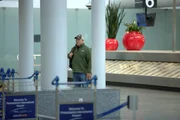 Der CBP-Aufsichtsbeamte Adams trägt Zivilkleidung und einen Rucksack, als er bei seiner verdeckten Arbeit am Philadelphia International Airport in Philadelphia, Pennsylvania, die Gepäckausgabe durchstreift.