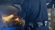 Ein CBP-Beamter untersucht in Los Angeles mit einer Säge eine transportierte Maschine auf möglicherweise versteckte Drogen.