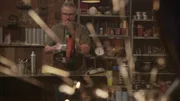 Sparks out of focus in foreground. J in background cutting metal on bandsaw