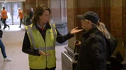 Alexandra hilft einer sehbehinderten Frau am Amsterdamer Hauptbahnhof. Eine Luftaufnahme zeigt den Transport eines Brückenteils durch Wasser in Amsterdam, Niederlande.
