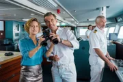 Für die Reise nach Nusantara bringt Kapitän Max Parger (Florian Silbereisen, M.) zur Überraschung seines Staff-Kapitäns Martin Grimm (Daniel Morgenroth, r.) Veronika Bruckner (Wanda Perdelwitz) mit an Bord.