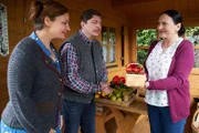 Frau Grasegger (Ursula Maria Burkhart, r.) hat in ihrem Schrebergarten zu viel Obst und Gemüse angebaut, sodass sie ihren Nachbarn Annegret (Eva Wittenzellner, l.) und Hartmut Nerlinger (Georg Veitl, M.) einen Teil davon schenkt.