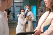 Fadila Awad (Eman Dwagy, li. hinten) will gerade ihren neugeborenen Sohn sehen, als Dr. Ina Schulte (Isabell Gerschke, re. hinten) sie gerade noch zurückhalten kann. Ina hat gerade die Untersuchungsergebnisse von Fadila bekommen.