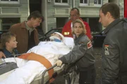 Während Sabine und Paul die Patientin verladen, verspricht Herbert der verletzten Tatjana, dass er gut auf Georg aufpassen wird.