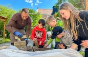 Der Sommer kann kommen – im Kindergarten und Hort Braunichswalde wird eine Outdoor-Dusche gebaut. Marco Oertel ist einer der fleißigen Helfer und erklärt den Kindern, wie's geht.