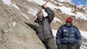 Einsatzleiter Kevin May (L) und Paläontologe Dr. Pat Druckenmiller machen einen Weg an einem Felsen entlang des Colville River frei.