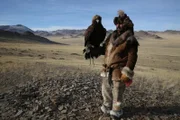 Bayan Olgii, Mongolia: Hazen Audel with a golden eagle, wearing traditional hunting clothes.