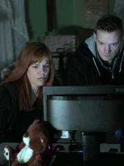 Amy Bruni and Adam Berry looking at a monitor during a nighttime investigation at the Villisca Ax House in Villisca, IA.