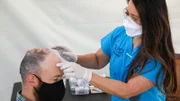 Dr. Lee examines the bumps on Adam’s head.
