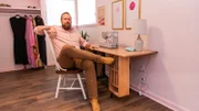 Ben Napier sits next to the sewing station he built for the homeowner at The Davis house, as seen on Home Town, Season 7.
