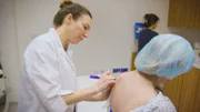 Shot of Dr Emma marking up Josée for her surgery