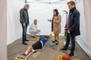 Gerichtsmedizinerin Dr. Franziska Beck (Maria Happel, M.) erklärt ihren Kollegen Major Carl Ribarski (Stefan Jürgens, l.), Bezirksinspektor Simon Steininger (Michael Steinocher, r.) und Spurensicherer Franz Wohlfahrt (Helmut Bohatsch, hinten M.), wie Adam Posch mit einem Blumentopf erschlagen wurde.