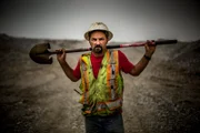 Dave Turin holding a shovel over his shoulders.